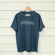 Blå T-shirt scouterna 1910 hängandes på galge mot vägg